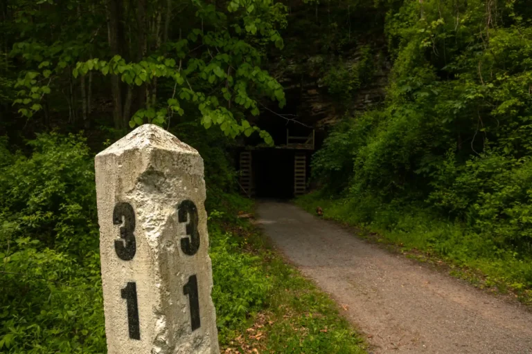Rail mile marker along rail trail with tunnel in background